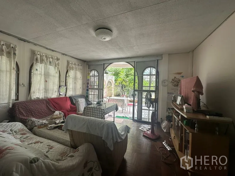 Detached House for sale in Phra Khanong, Bangkok - Ground-floor living room with arched doors opening to the terrace and garden.