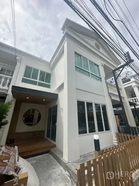 带办公室的家 出租在Khlong Toei, Bangkok - 现代白色联排外立面，大窗户、小前廊与木栅栏。