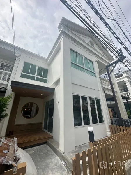 带办公室的家 出租在Khlong Toei, Bangkok - 现代白色联排外立面，大窗户、小前廊与木栅栏。