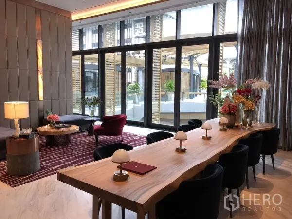 คอนโด ขายในWatthana, Bangkok - เลานจ์ส่วนกลางตกแต่งหรู มีโต๊ะยาวไม้และกระจกเต็มบานมองเห็นสระน้ำ
