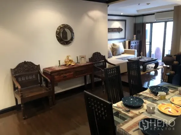 公寓 出租在Watthana, Bangkok - 木质餐桌旁的用餐角，连接明亮客厅与阳台门。