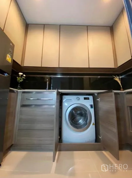 Condominium for rent or sale in Phaya Thai, Bangkok - Kitchen base cabinet revealing an integrated front-load washing machine.