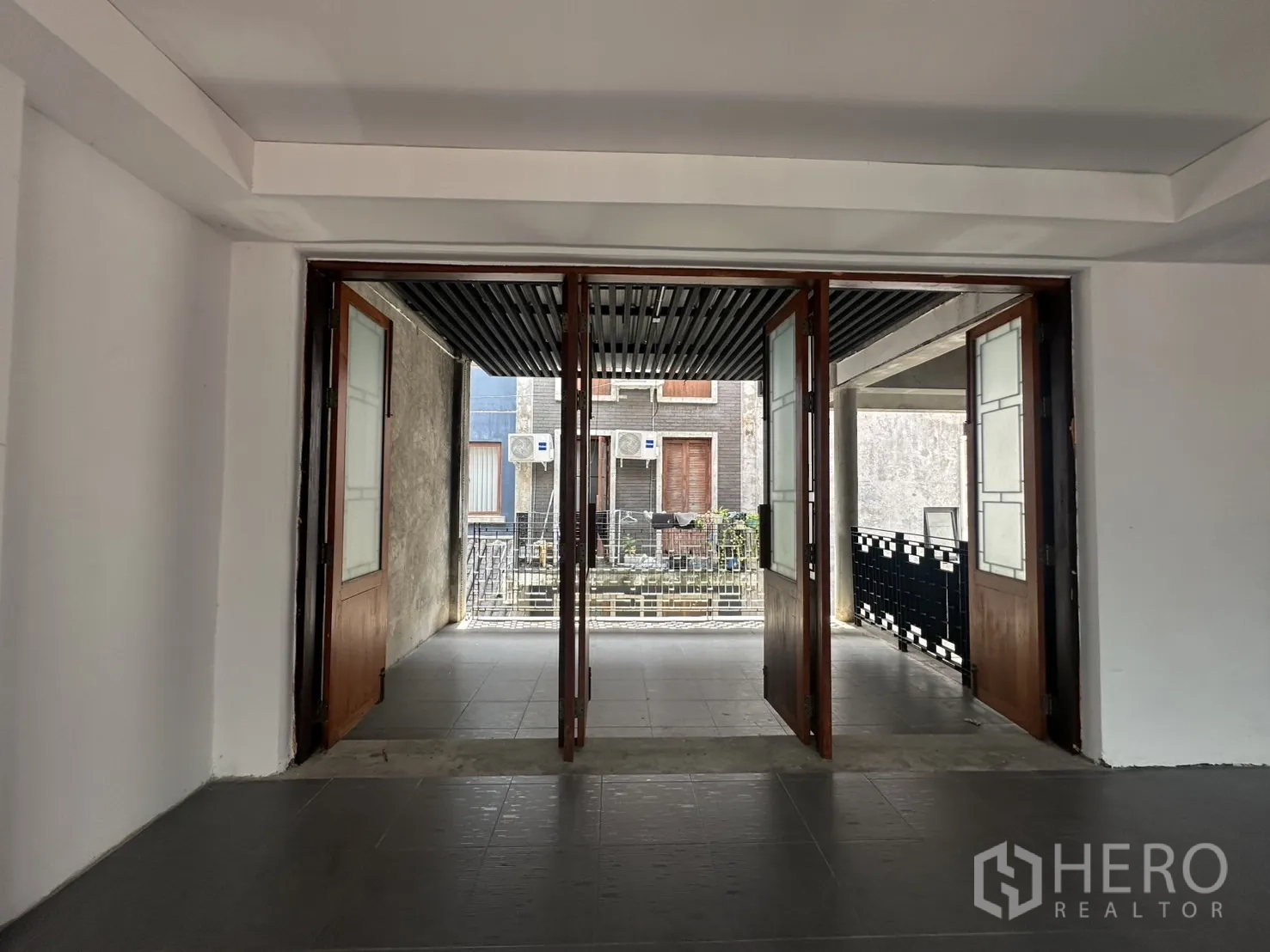 带办公室的家 出租在Pathum Wan, Bangkok - 室内透过折叠木玻璃门，通向半室外走廊。