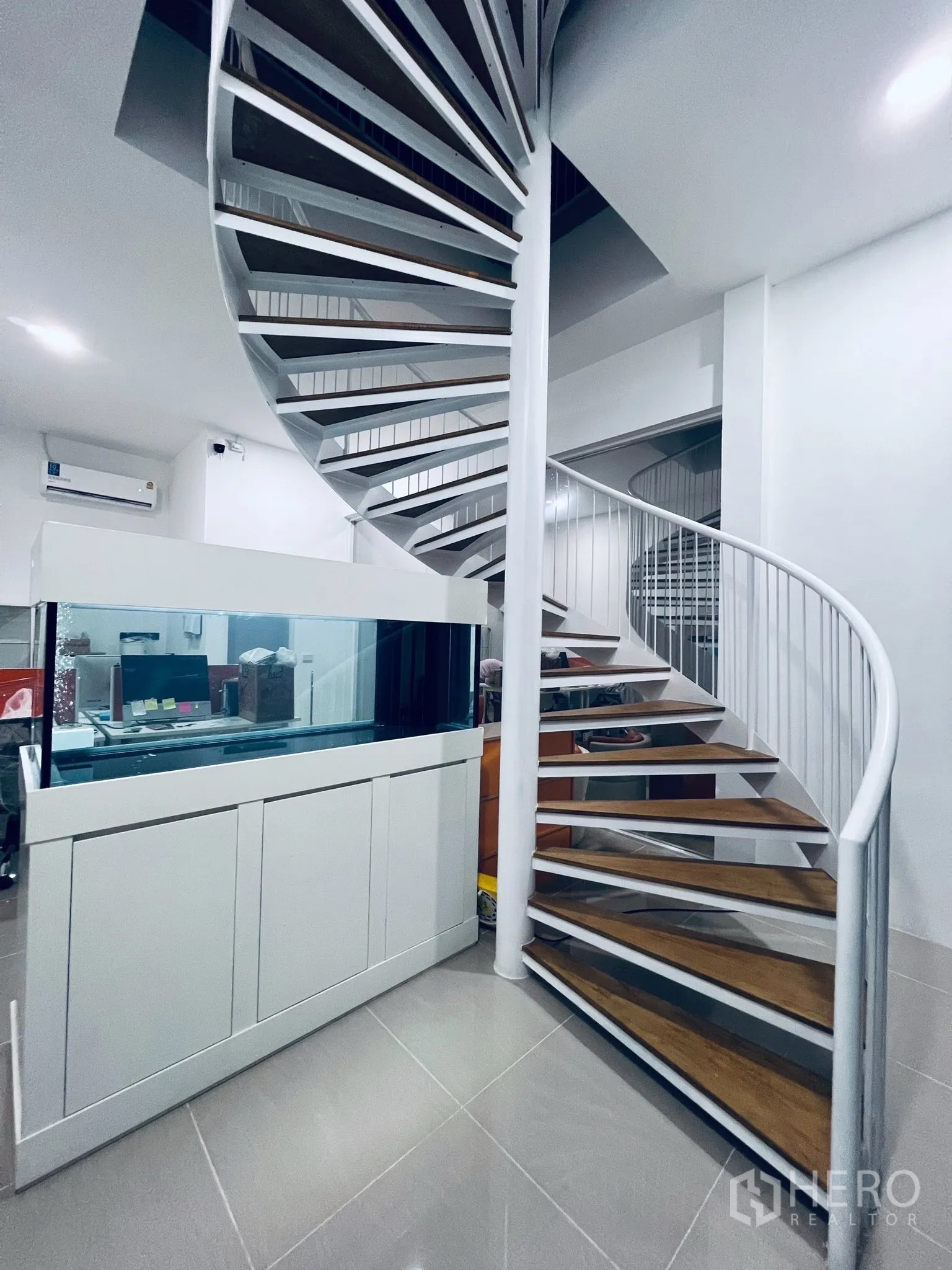 仓库 for sale in Lat Lum Kaeo, Pathum Thani - 现代白色旋转楼梯，木质踏板，旁有接待柜。