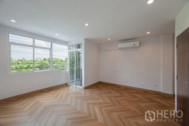联排别墅 出售在Lat Phrao, Bangkok - 宽敞卧室，多扇窗、空调与阳台出入口。