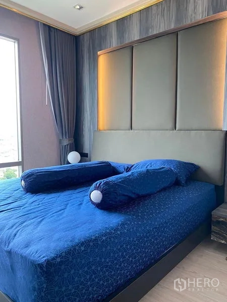 公寓 出售在Bang Kho Laem, Bangkok - 主卧，软包床头、蓝色床品与转角窗。