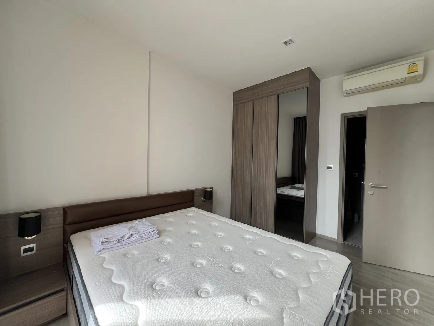 คอนโด for rent in Watthana, Bangkok - มุมห้องนอนเห็นตู้เสื้อผ้าบานกระจกและเครื่องปรับอากาศติดผนัง.