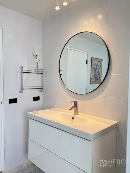 Condominium for rent in Khlong Toei, Bangkok - Another view of the bathroom vanity with circular mirror, drawers and lighting.