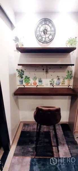 Condominium for rent or sale in Huai Khwang, Bangkok - Work-from-home nook with bar-height desk, floating shelves, and wall clock.