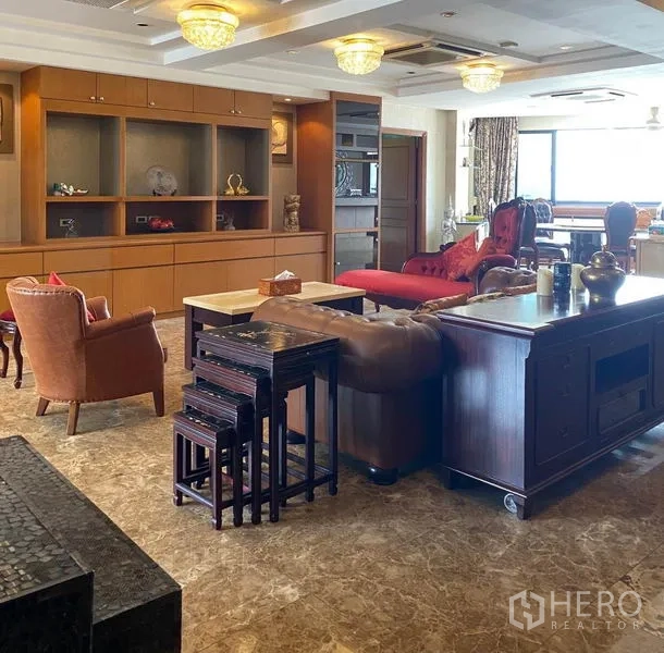 Condominium for rent in Khlong Toei, Bangkok - Expansive living room with marble floors, wood cabinetry and classic seating.