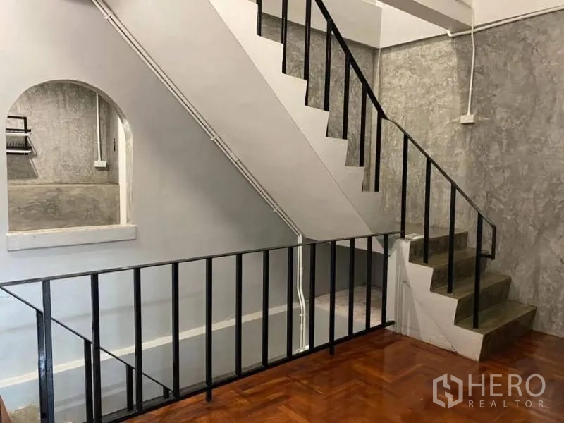 带办公室的家 出租在Bang Rak, Bangkok - 室内楼梯，黑色扶手与水泥台阶，旁有拱形壁龛。