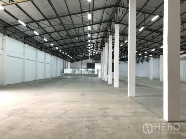 คลังสินค้า ให้เช่าในNonthaburi - มุมมองทางเดินยาวของโกดัง แสดงแถวเสารับน้ำหนัก หลังคาพร้อมฉนวน และผนังสีขาวสว่าง