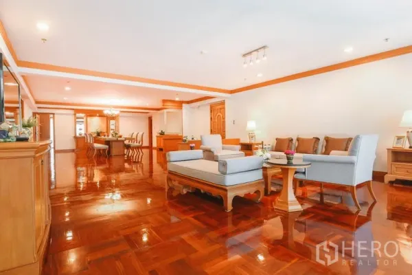 Apartment for rent in Watthana, Bangkok - Open-plan living and dining area with seating set, parquet floors, ceiling lights and generous space.