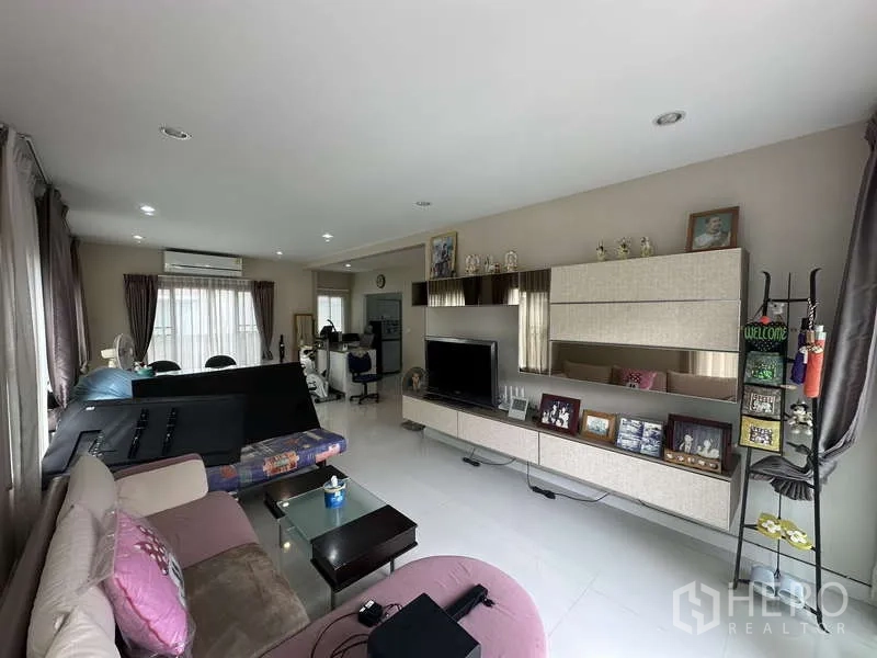 Detached House for sale in Sai Mai, Bangkok - Bright lounge area with shelving, TV cabinet and seating.