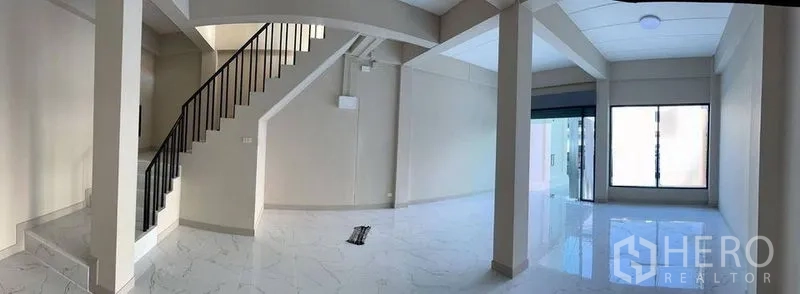 店屋 出租在Bang Kapi, Bangkok - 开放式室内布局，楼梯与玻璃店面入口。
