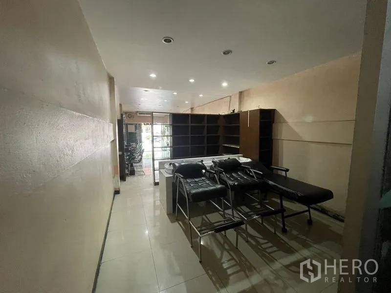 Shophouse for rent in Phra Khanong, Bangkok - Rear section with shelving and treatment beds under downlights.