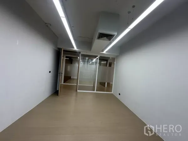 办公空间 出租在Watthana, Bangkok - 封闭式办公室，线性灯、玻璃门与木纹地板。