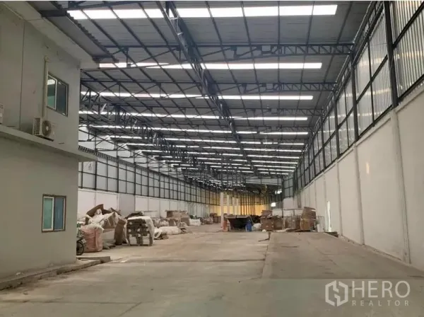 Warehouse for rent in Nakhon Pathom - Another angle of the large warehouse showing a side office box, clerestory windows and skylights, with a clear central aisle for vehicle movement.