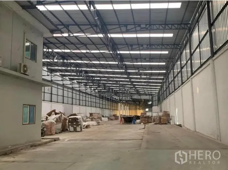 Warehouse for rent in Nakhon Pathom - Another angle of the large warehouse showing a side office box, clerestory windows and skylights, with a clear central aisle for vehicle movement.