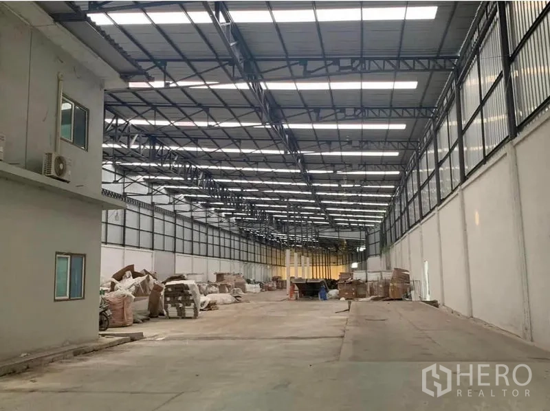 Warehouse for rent in Nakhon Pathom - Another angle of the large warehouse showing a side office box, clerestory windows and skylights, with a clear central aisle for vehicle movement.