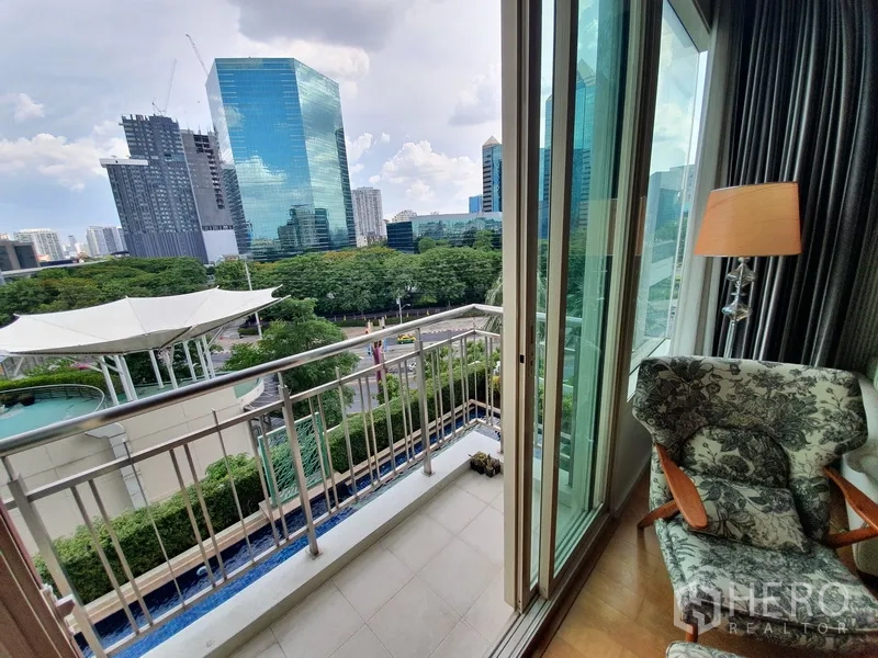 Condominium for rent in Chatuchak, Bangkok - Compact balcony with metal railing and city-park outlook, sliding doors open from the living room.