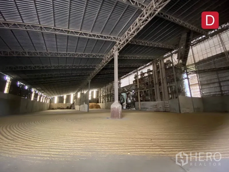 Factory for rent in Chachoengsao - Factory floor with machinery line and a forklift under corrugated metal roofing.