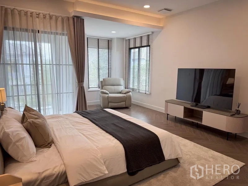 Detached House for rent or sale - Spacious master bedroom with large windows, a TV console, and a cozy seating area.