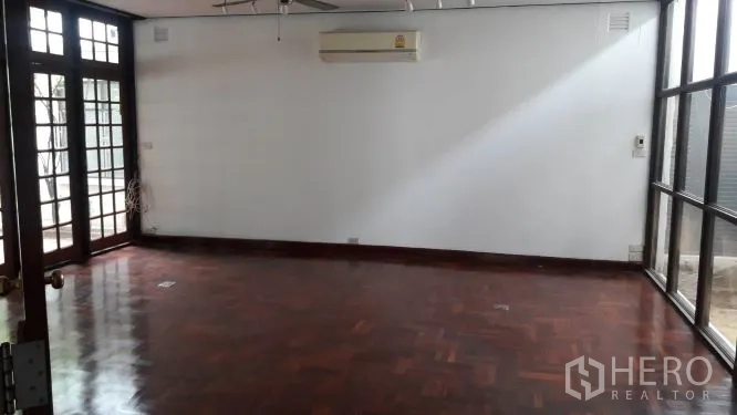 Detached House for rent in Yan Nawa, Bangkok - Additional living area with parquet floor, split air-conditioning, and large windows.