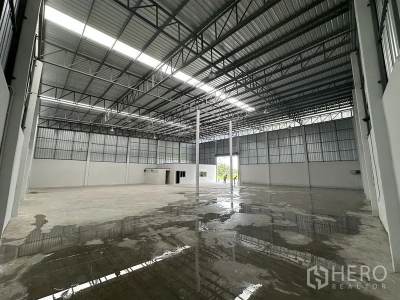 Warehouse for rent in Sai Noi, Nonthaburi - Polished concrete floor area inside the warehouse with wide‑span steel trusses.