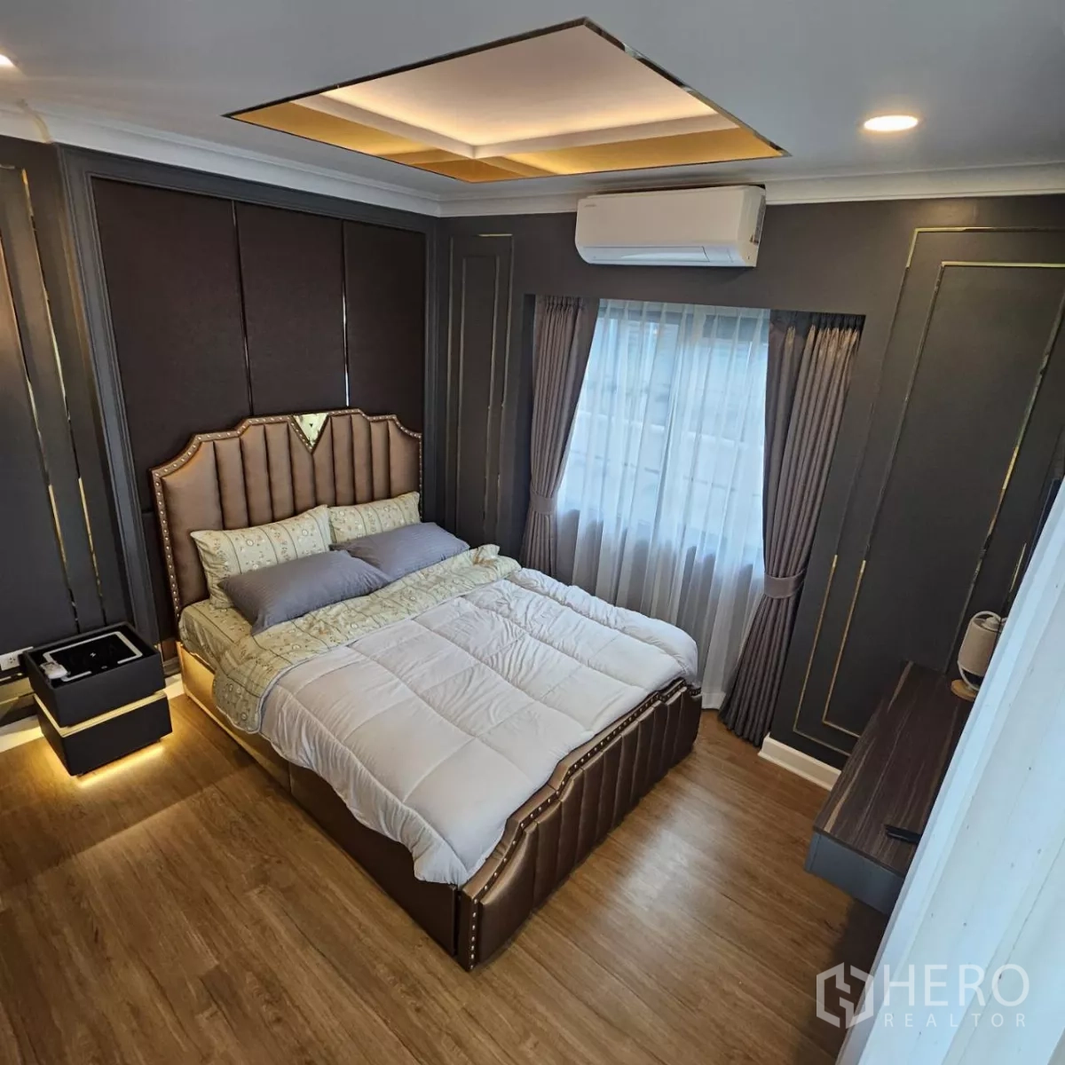 独立式住宅 出租在Bang Phli, Samut Prakan - 时尚卧室，软包床头、深色护墙板、窗帘与木地板。