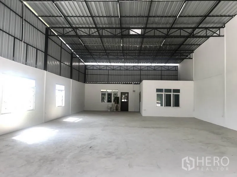 Warehouse for rent in Pathum Thani - Bright warehouse interior with 6 m high ceiling, concrete floor and built-in office rooms.