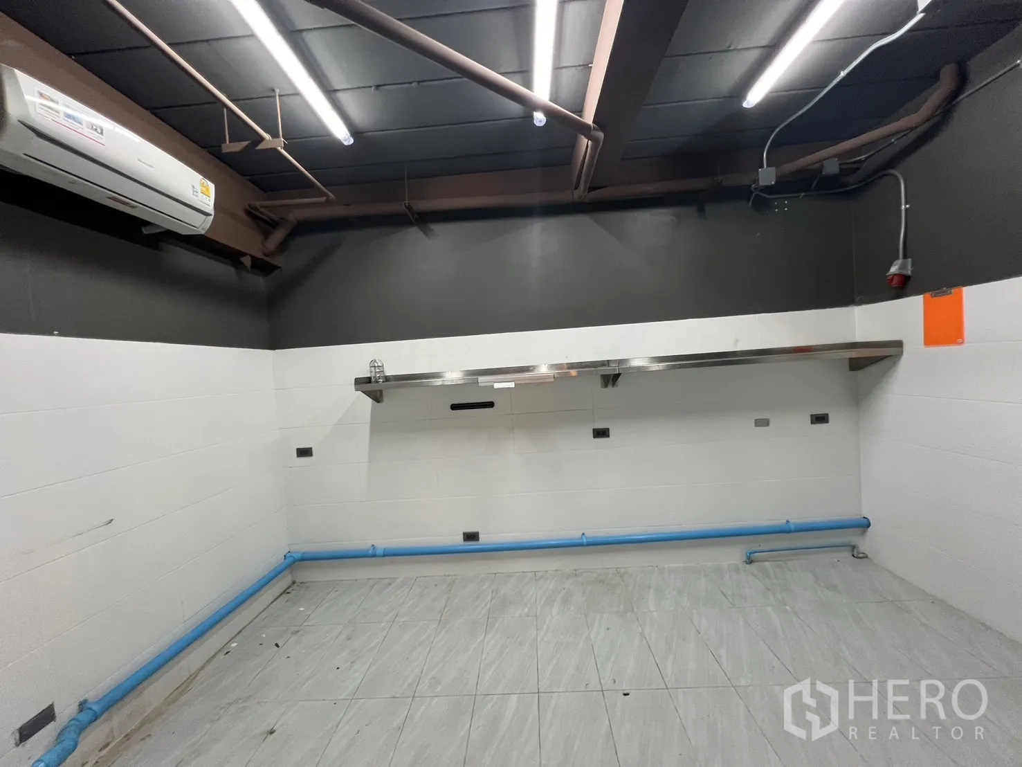 Retail Space for rent in Watthana, Bangkok - Air‑conditioned prep room with tiled floor, wall-mounted stainless shelf and service piping.