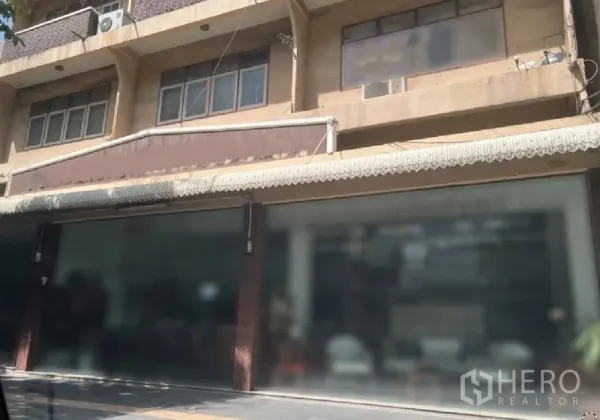Retail Space for rent in Watthana, Bangkok - Wide row of ground-floor glass shopfronts under a long awning with upper-floor windows and AC units above.