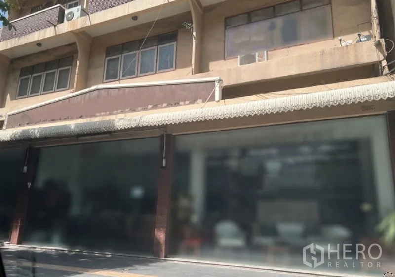 Retail Space for rent in Watthana, Bangkok - Wide row of ground-floor glass shopfronts under a long awning with upper-floor windows and AC units above.