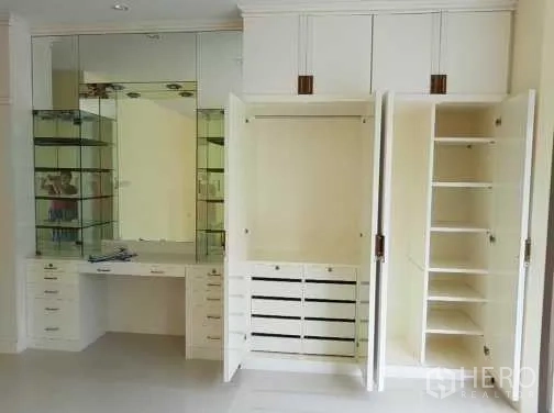 联排别墅 出租在Khlong Toei, Bangkok - 卧室内白色内置衣柜与镜面梳妆台。