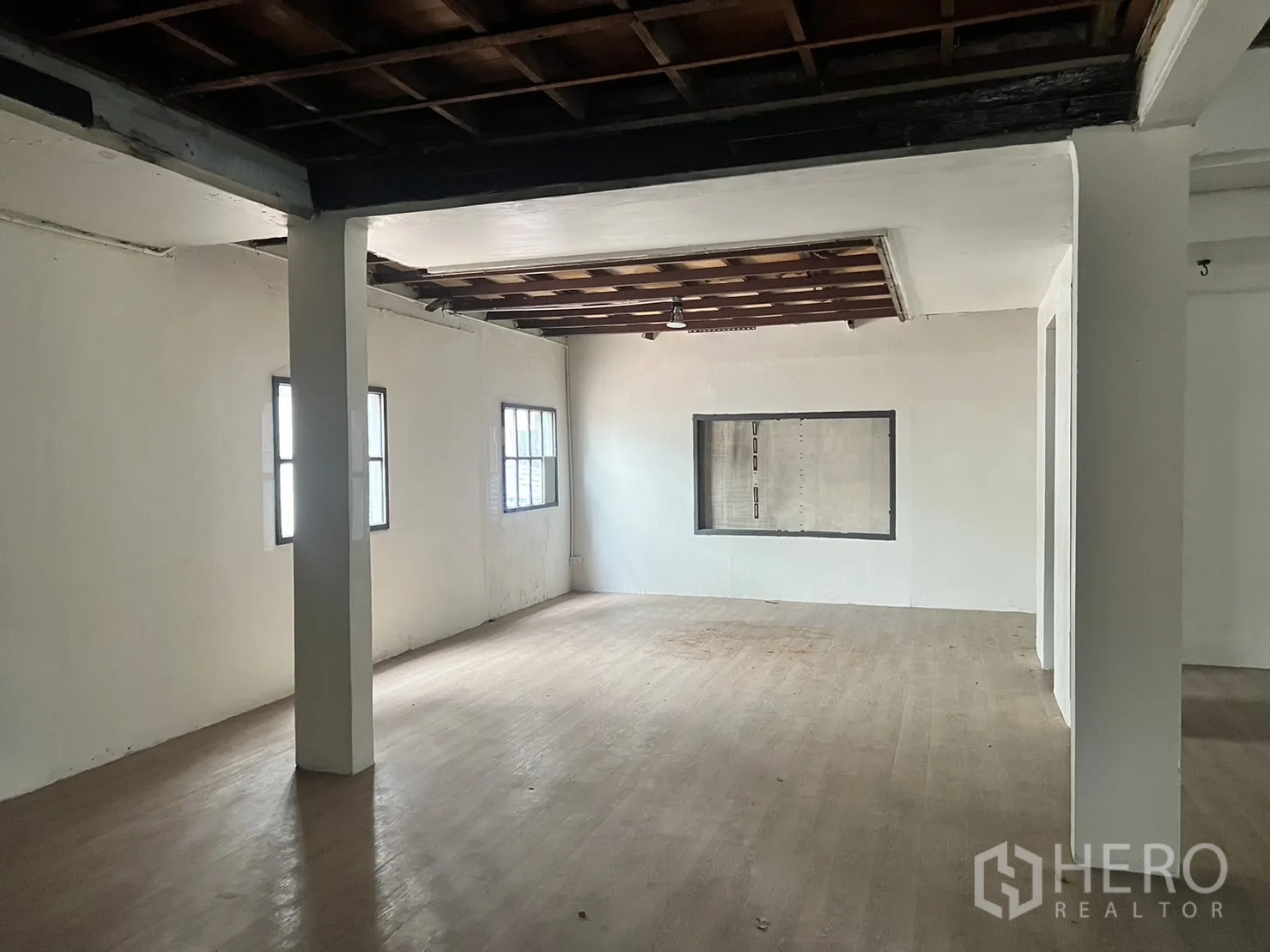 零售空间 出租在Watthana, Bangkok - 开间房内设中央立柱、两扇窗与墙体展示开口。