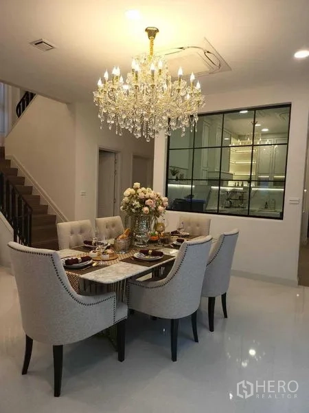 Detached House for rent in Saphan Sung, Bangkok - Dining room view toward a glass-partition kitchen and staircase.