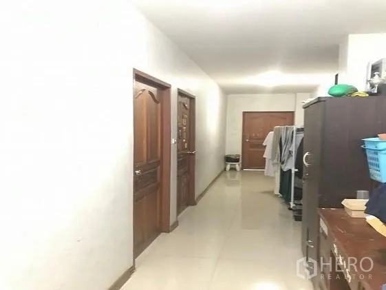 Factory for sale in Khlong Luang, Pathum Thani - Bright corridor with wooden doors leading to staff rooms and facilities.