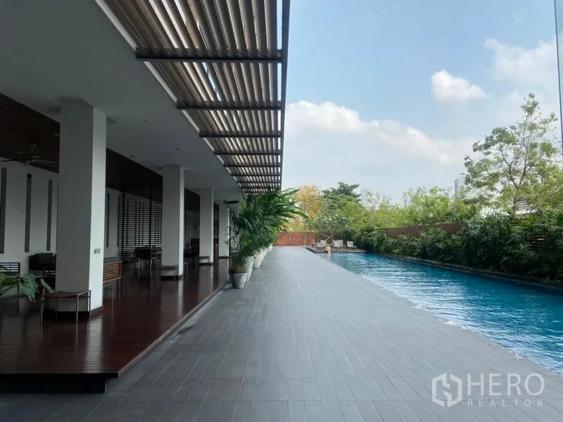 公寓 出租在Yan Nawa, Bangkok - 室外长条泳池，带遮荫平台、座椅与绿化景观。