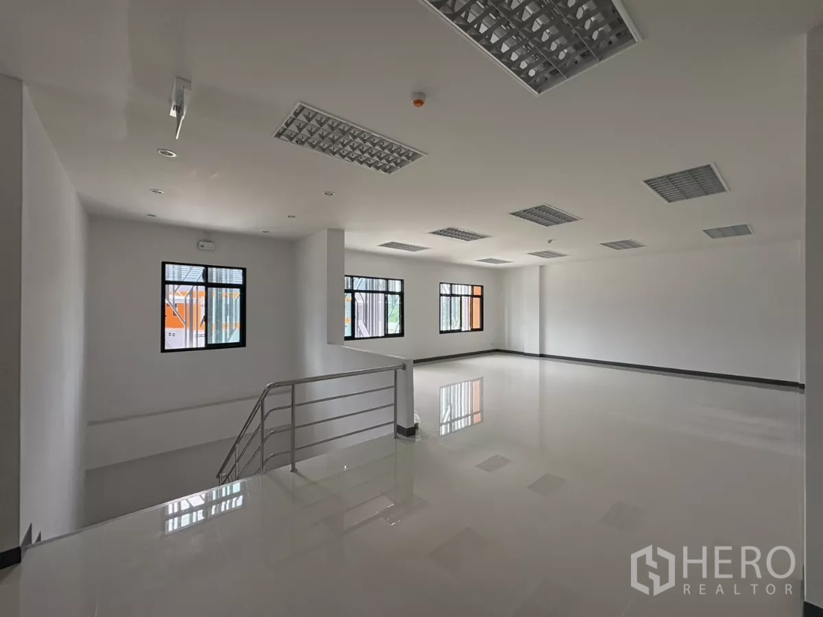 工厂 出租在Bang Pakong, Chachoengsao - 二层开放式办公室区域，设窗户与楼梯栏杆。