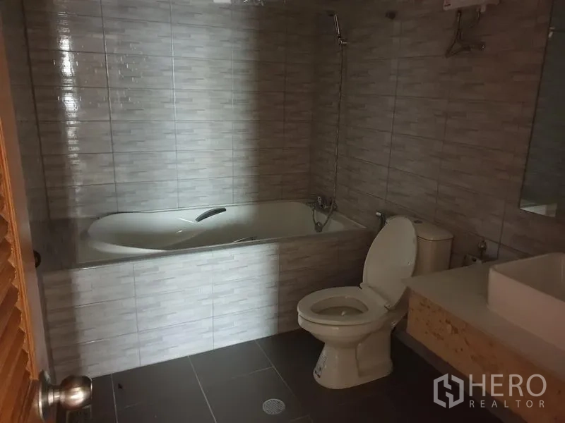 คอนโด ให้เช่าในWatthana, Bangkok - ห้องน้ำมีอ่างอาบน้ำ โถสุขภัณฑ์ และเคาน์เตอร์อ่างล้างหน้า ผนังกระเบื้องสีเทา