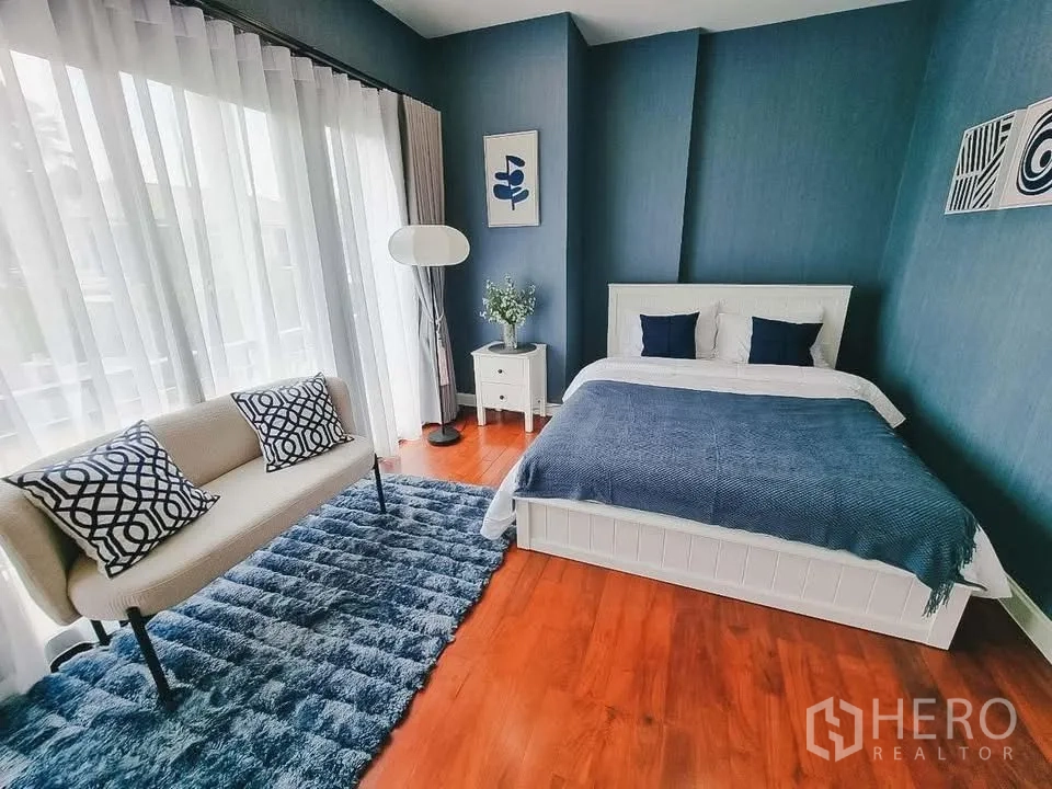 独栋房屋 for rent or sale in Bang Phli, Samut Prakan - 蓝色主题卧室，配床、双人小沙发与大面积窗帘。