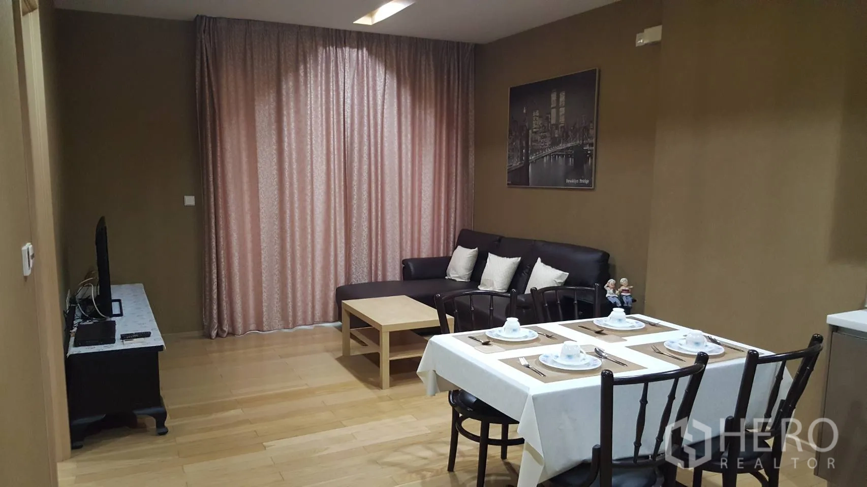 Condominium for rent in Khlong Toei, Bangkok - Open-plan living and dining area with sofa, coffee table and TV.