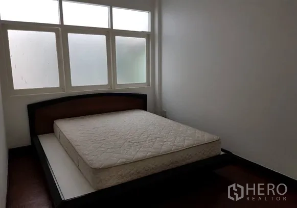 Shophouse for rent in Watthana, Bangkok - Bedroom with bed frame, mattress and frosted windows.