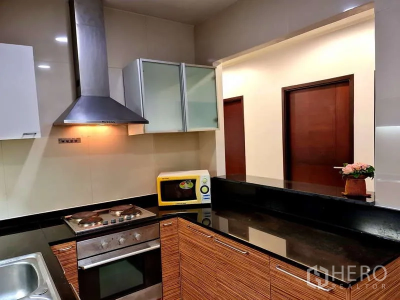 Apartment for rent - Kitchen view showing cooktop, stainless hood, microwave and breakfast counter.