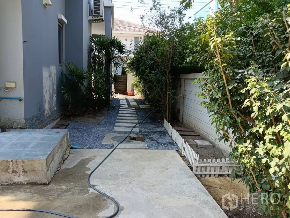 独立式住宅 出售在Lat Krabang, Bangkok - 阴凉的侧边通道，踏步步道与浓密绿植。