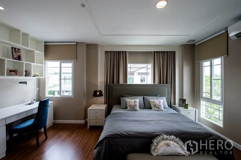 Detached House for sale in Bang Kapi, Bangkok - Master bedroom view showing built-in desk and shelving by corner windows.