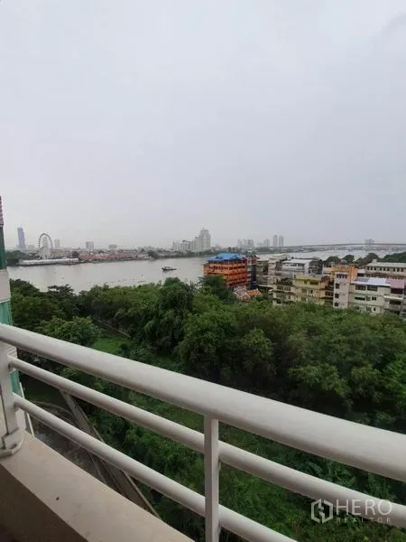 公寓 出租在Khlong San, Bangkok - 白天阳台景观，俯瞰昭拍耶河、绿地与低层建筑。