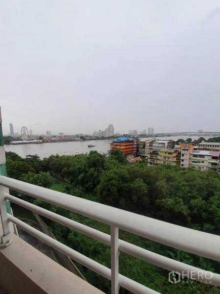 公寓 出租在Khlong San, Bangkok - 白天阳台景观，俯瞰昭拍耶河、绿地与低层建筑。