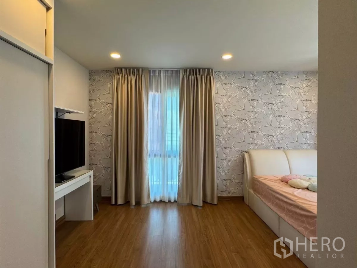 独立式住宅 出租在Bang Phli, Samut Prakan - 客卧带花纹墙纸、电视柜和日间床。